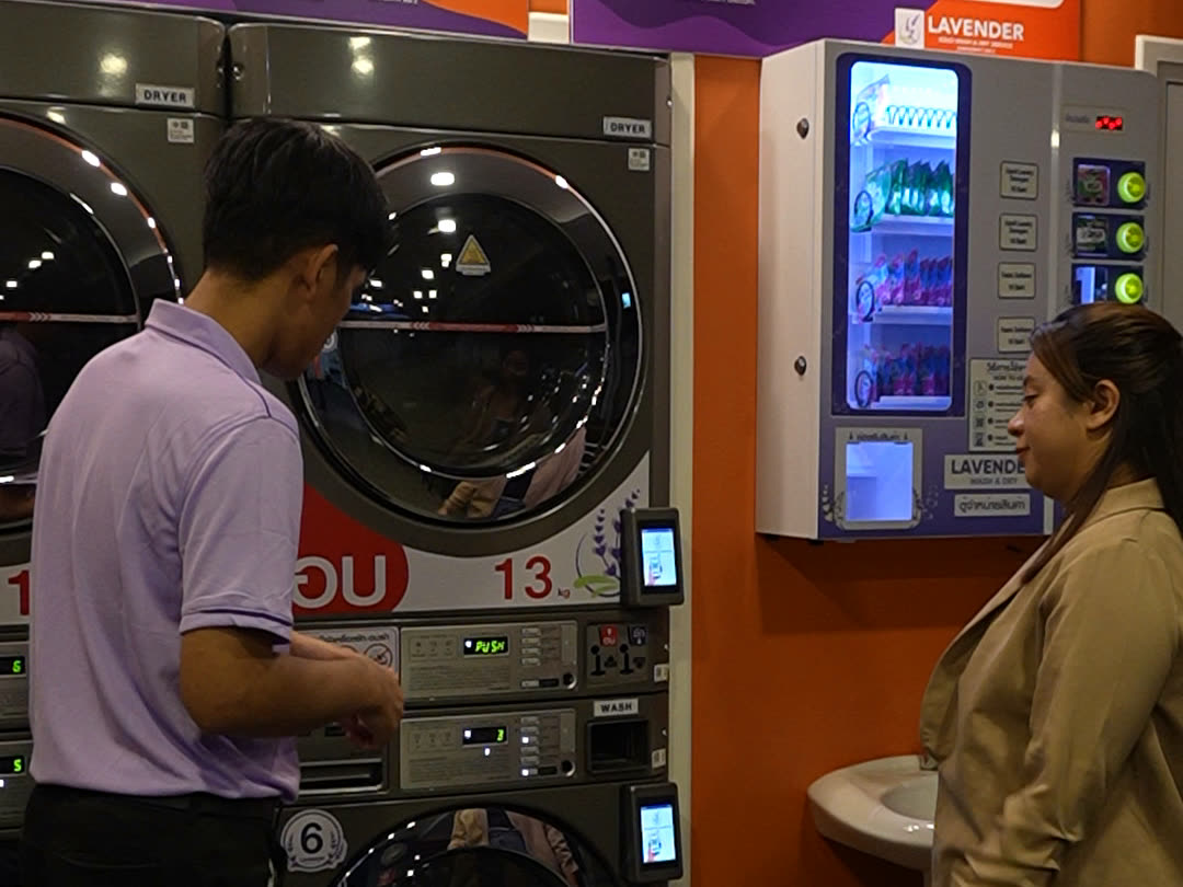 A Lavender staff member helping a customer at the machines